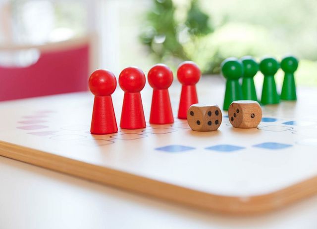 Spielbrett für Mensch ärgere dich nicht mit acht Spielfiguren und zwei Würfeln. 